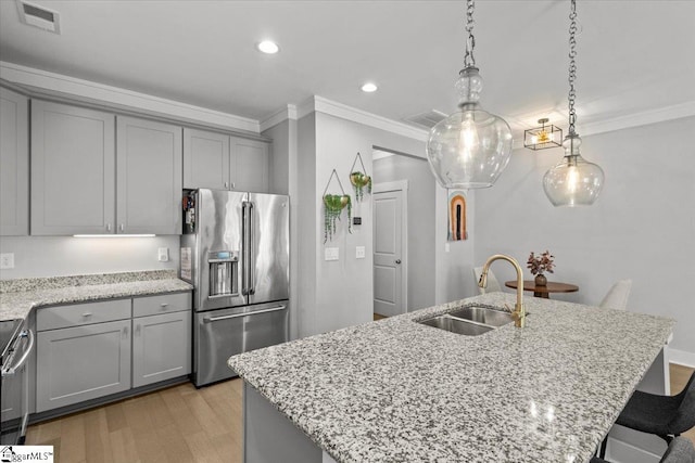 kitchen with light hardwood / wood-style floors, sink, a center island with sink, and stainless steel appliances