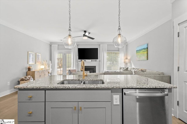 kitchen featuring stainless steel dishwasher, a wealth of natural light, ceiling fan, and light hardwood / wood-style flooring