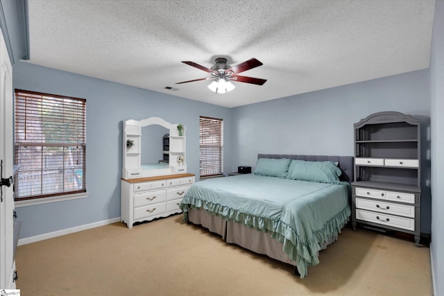 carpeted bedroom with a textured ceiling and ceiling fan