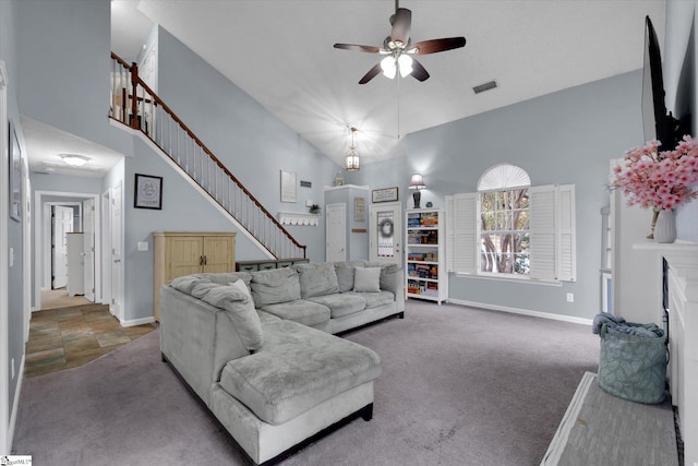 carpeted living room with ceiling fan and high vaulted ceiling