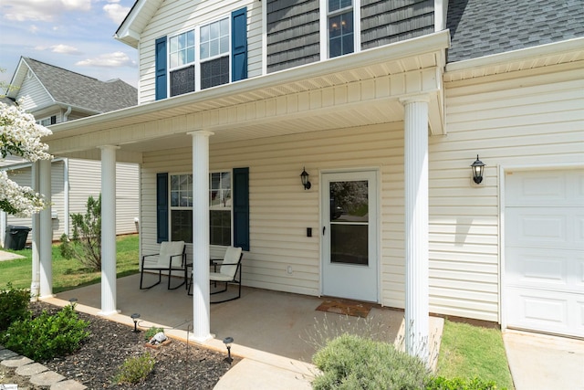 doorway to property with a garage and a porch