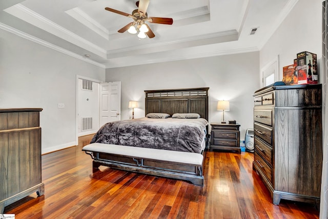 bedroom featuring dark wood-type flooring, ceiling fan, ornamental molding, and a raised ceiling