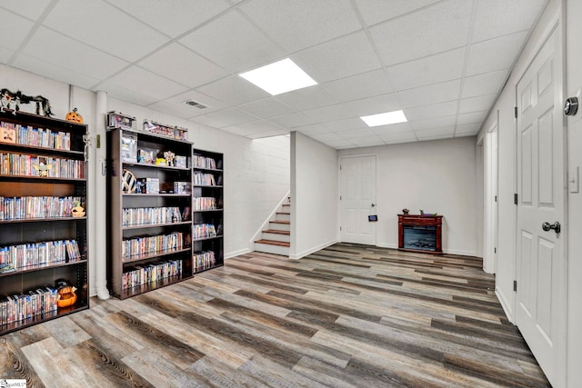 basement featuring wood-type flooring and a drop ceiling