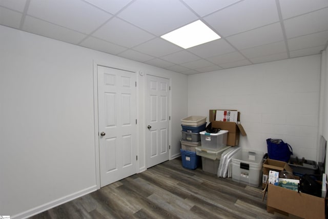 interior space with a paneled ceiling and dark hardwood / wood-style flooring