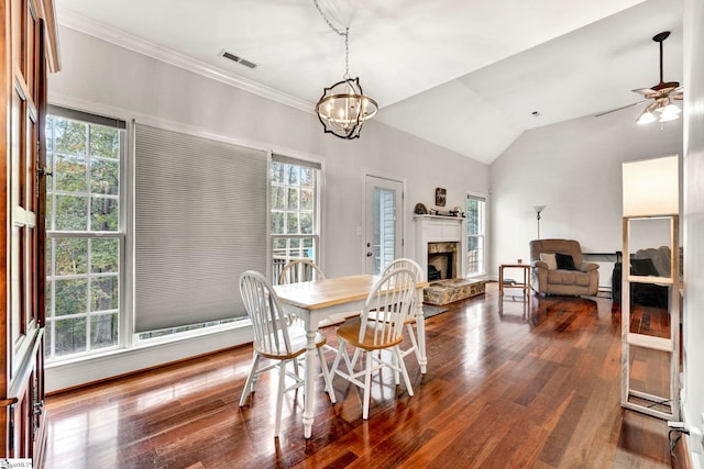 dining space with lofted ceiling, a healthy amount of sunlight, dark hardwood / wood-style floors, and ceiling fan with notable chandelier