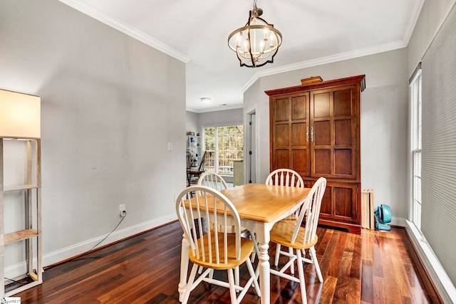 dining room with dark hardwood / wood-style floors, ornamental molding, and an inviting chandelier