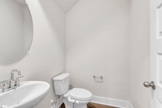 bathroom with lofted ceiling, wood-type flooring, sink, and toilet