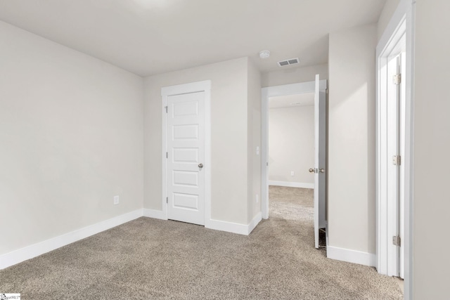 unfurnished bedroom featuring a closet and light colored carpet