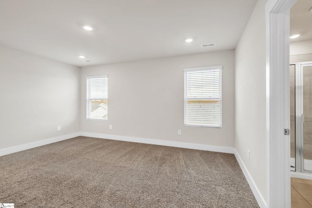 spare room featuring light colored carpet