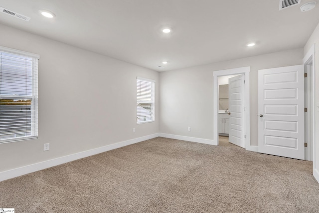 unfurnished bedroom featuring carpet flooring and ensuite bathroom