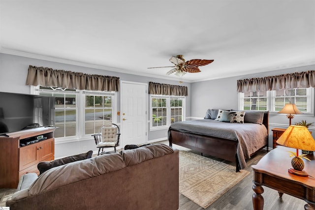 bedroom with hardwood / wood-style flooring, multiple windows, and ornamental molding