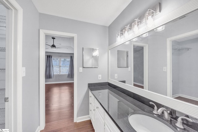 bathroom featuring hardwood / wood-style floors, ceiling fan, vanity, and a textured ceiling