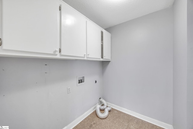 clothes washing area featuring a textured ceiling, electric dryer hookup, cabinets, and washer hookup