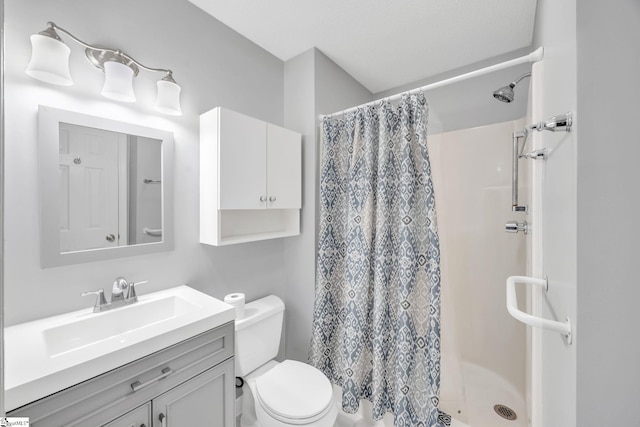 bathroom featuring walk in shower, vanity, and toilet