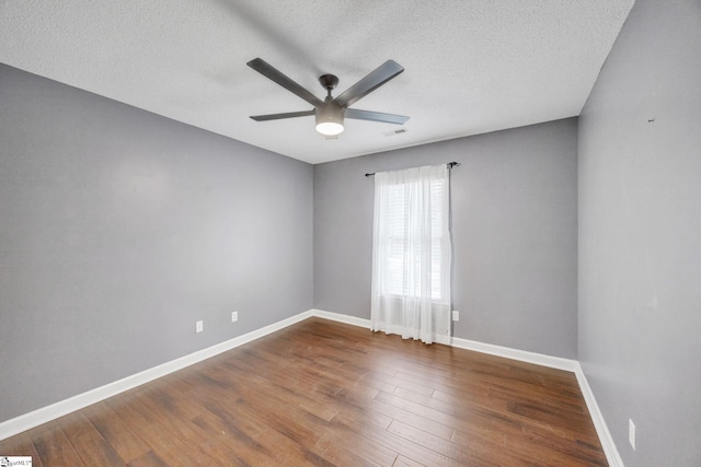 empty room featuring ceiling fan, wood-type flooring, and a textured ceiling