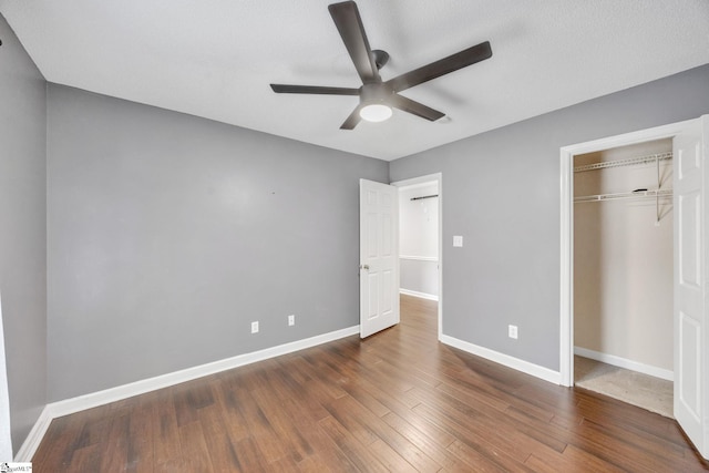 unfurnished bedroom featuring a textured ceiling, dark hardwood / wood-style flooring, ceiling fan, and a closet