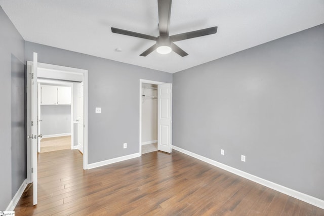 unfurnished bedroom featuring ceiling fan, a textured ceiling, a closet, and wood-type flooring