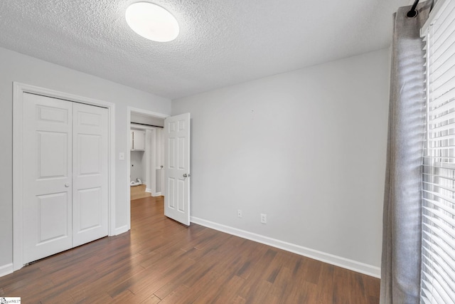 unfurnished bedroom with dark wood-type flooring, a closet, and a textured ceiling