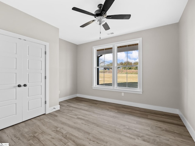 unfurnished bedroom with light hardwood / wood-style flooring, ceiling fan, and a closet