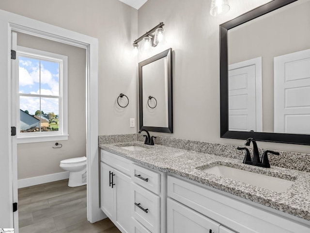 bathroom featuring toilet, vanity, and wood-type flooring