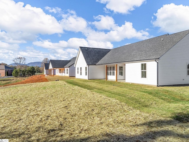 back of house featuring a lawn