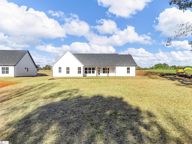 rear view of house featuring a lawn