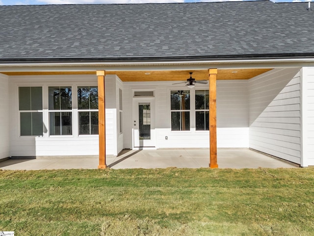 property entrance featuring ceiling fan, a lawn, and a patio area