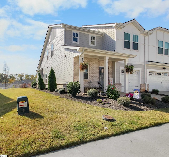 view of front of home featuring covered porch, a garage, and a front lawn