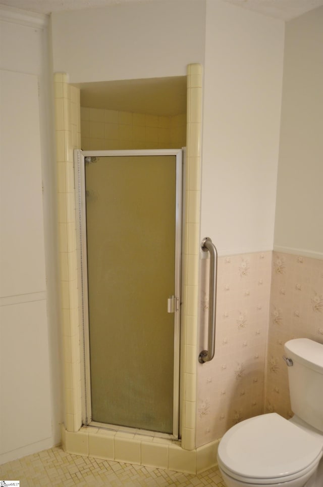 bathroom with toilet and an enclosed shower