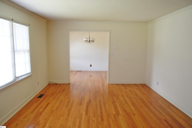 unfurnished room featuring light hardwood / wood-style floors, a chandelier, and crown molding