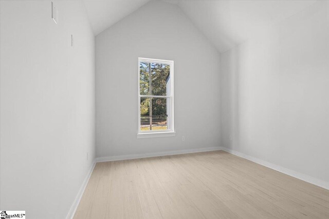 additional living space with vaulted ceiling and light wood-type flooring