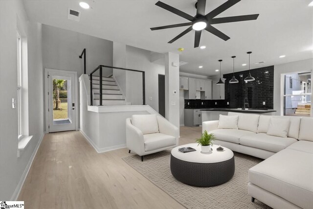 living room with ceiling fan and light wood-type flooring