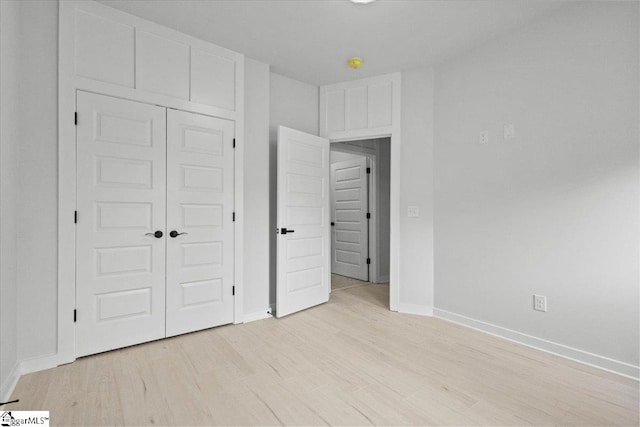 unfurnished bedroom featuring light wood-type flooring and a closet