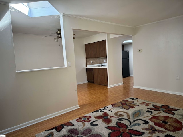 interior space with ceiling fan, light hardwood / wood-style flooring, and crown molding