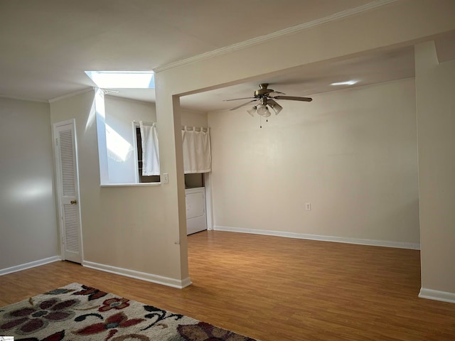 spare room with hardwood / wood-style flooring, ceiling fan, washer / dryer, and crown molding