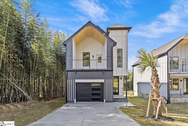 view of front of home featuring a balcony, a front yard, and a garage