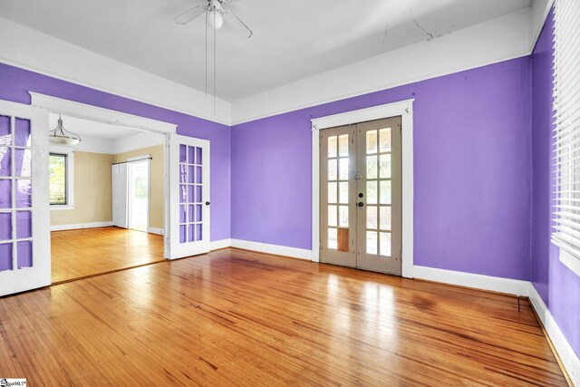 1303 E River St, Anderson, SC 29624 - empty room with french doors, ceiling fan, wood finished floors, and healthy amount of natural light