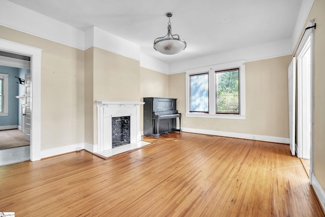 1303 E River St, Anderson, SC 29624 - unfurnished living room with a fireplace, light wood-type flooring, and baseboards