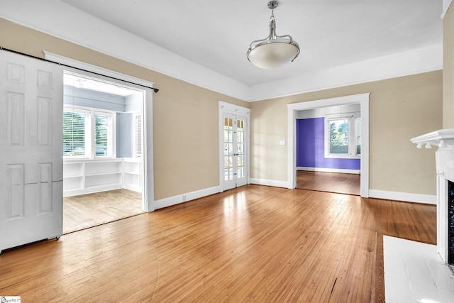 1303 E River St, Anderson, SC 29624 - unfurnished living room with light wood-style floors, a fireplace with flush hearth, baseboards, and french doors
