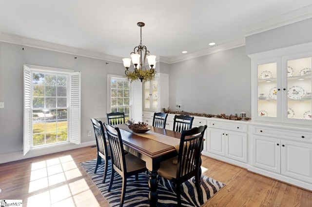 dining room featuring a chandelier, light hardwood / wood-style floors, and crown molding