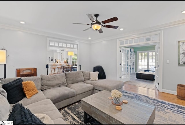 living room featuring ceiling fan, french doors, light wood-type flooring, and crown molding