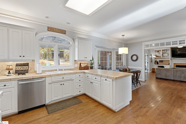 kitchen featuring tile counters, white cabinetry, and stainless steel dishwasher