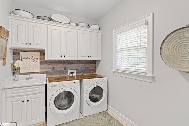 laundry room with cabinets, separate washer and dryer, and sink