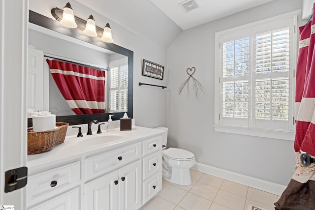 bathroom featuring tile patterned flooring, a wealth of natural light, vanity, and toilet