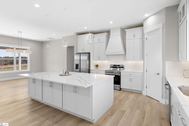 kitchen featuring stainless steel appliances, hanging light fixtures, custom exhaust hood, and a center island