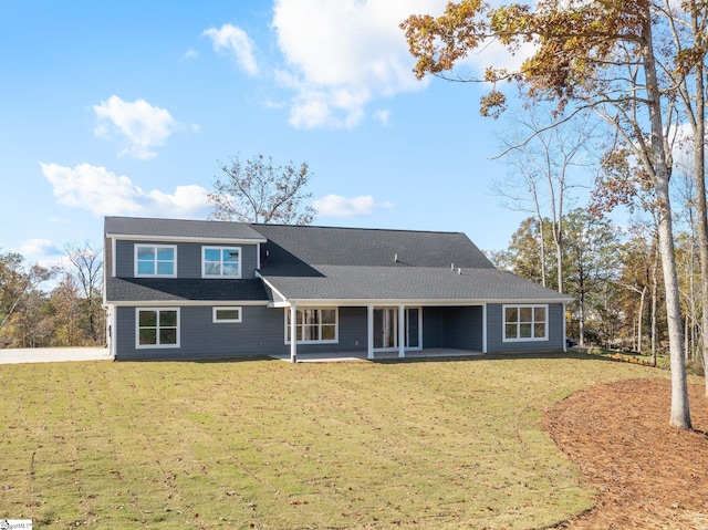 back of property with a yard and a patio area