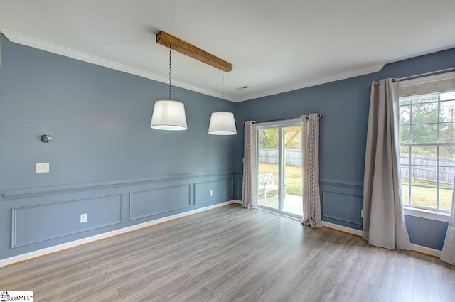 empty room with light hardwood / wood-style flooring and crown molding