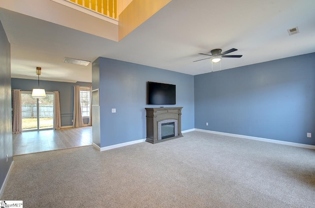 225 Worcester Ln, Easley, SC 29642 - unfurnished living room with carpet floors, a ceiling fan, baseboards, and a fireplace with flush hearth