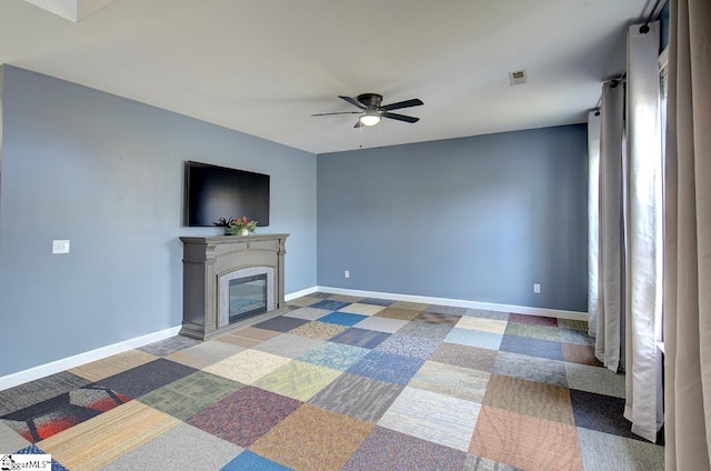 unfurnished living room featuring carpet floors and ceiling fan