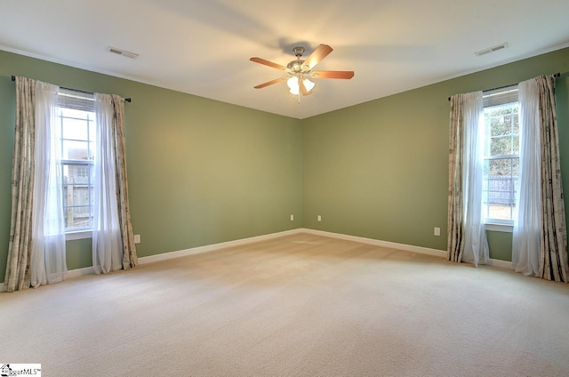 empty room featuring light colored carpet and plenty of natural light